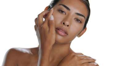 Tan Hispanic model touches cheek and shoulder, soft skin