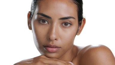 Young Latina props chin with back of hand, showing clean skin