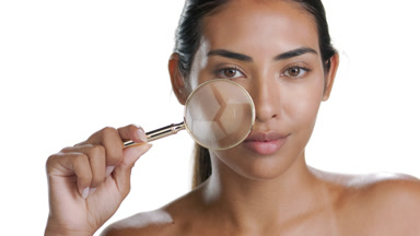 Latin model with tan skin magnifies face, exposes clear skin