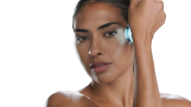 Young Latin American woman moves flask with blue liquid on face