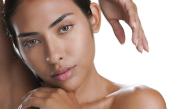 Warm-toned Latin woman touches chin, hand on head, soft skin