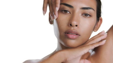 Tan Hispanic model touches chin, hand on head, pure skin