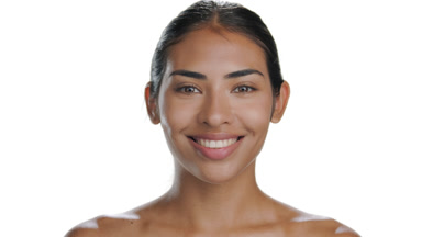 Young Latin model lifts gaze, smiles, accentuates smooth skin