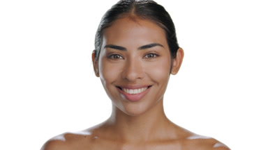 Young Latin woman smiles at camera, showing balanced skin
