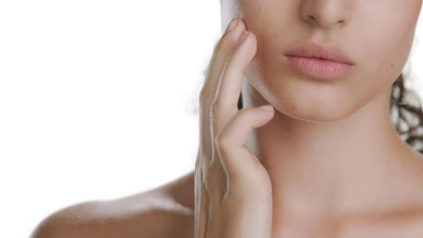 Fair-skinned model gently strokes cheek upwards