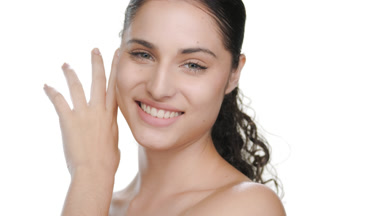 Light-complexioned Latina touches face, strokes cheek, pure skin
