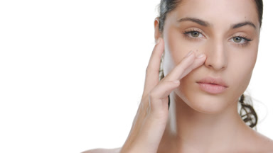 Hispanic woman with fair healthy skin strokes under-eye