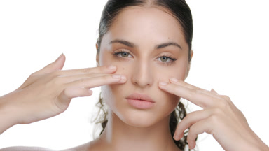 Latin model strokes under eyes, promotes elastic skin
