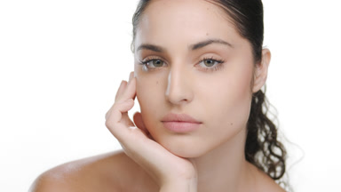 Latina with green eyes props chin, representing fresh fair skin