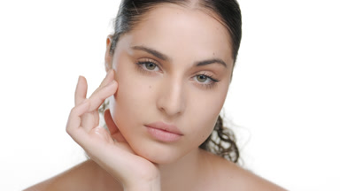 Green-eyed fair model props chin, spotlighting rejuvenated skin
