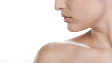 Young Hispanic woman strokes nape and shoulder, balanced skin