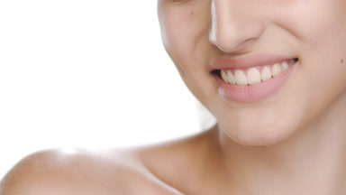 Fair young model strokes shoulder, smiles, balanced skin