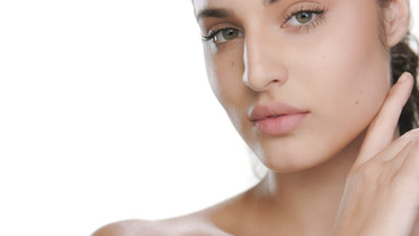 Youthful Latin brunette touches jawline, highlighting firm skin