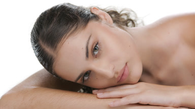 Latin model lifts head, touches chin, showcasing nourished skin