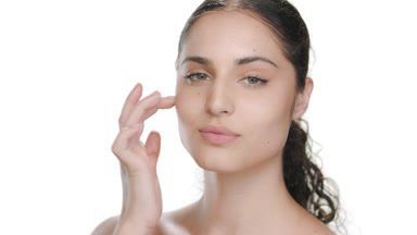 Fair-skinned model touches cheek twice with finger, elastic skin