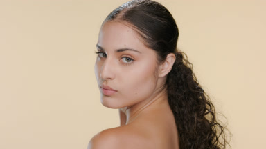 Fair-skinned Latin woman looks over shoulder, walks away