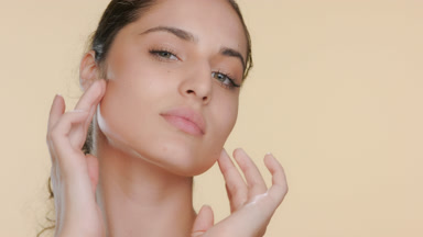 Fair Latina with green eyes slides fingers down cheeks