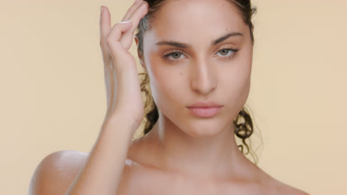 Fair-skinned green-eyed model strokes cheek upwards, soft skin