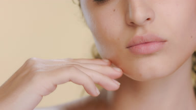 Young curly Latina touches chin, introducing elastic skin