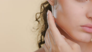 Light-complexioned curled Latina strokes jawline, firm skin