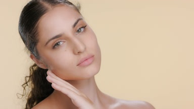 Youthful Latin brunette strokes jawline, healthy skin visual