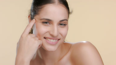 Hispanic model with green eyes props head, nourished skin