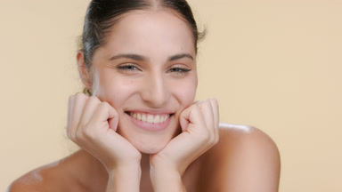 Green-eyed Latin brunette props chin, smiles, clear pure skin