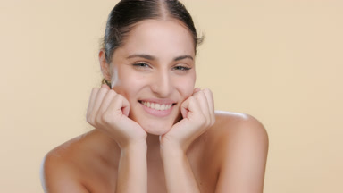 Youthful Latin brunette props chin, smiles, soft and fresh skin
