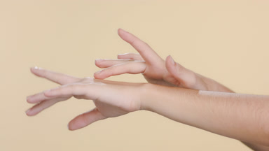 Light-skinned woman touches forearm, nourished hands