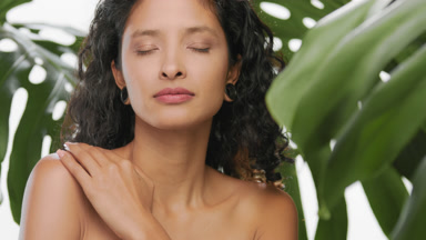 Latina woman strokes her shoulder with pleasure
