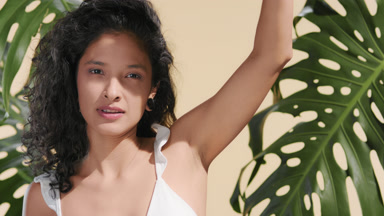 Latin woman shielding face from the sun with palm of her hand