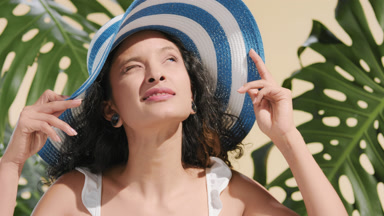 Funny beauty woman in sun hat lifts a brim and looks at the sun